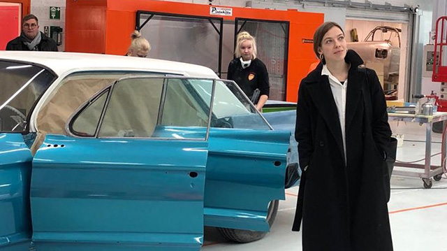 Opetusministeri Li Andersson tutustuu auton maalauslinjaan Hämeenlinnan ammatillisessa oppilaitoksessa.
